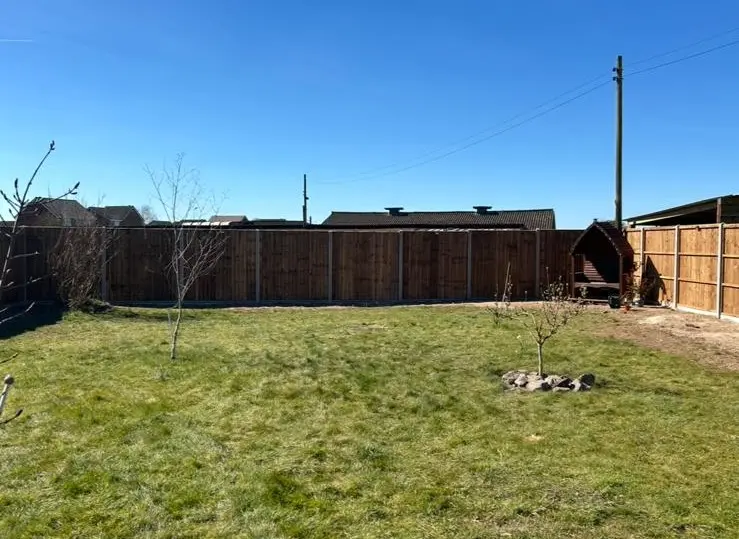 Newly installed featherboard fence panels around garden perimeter