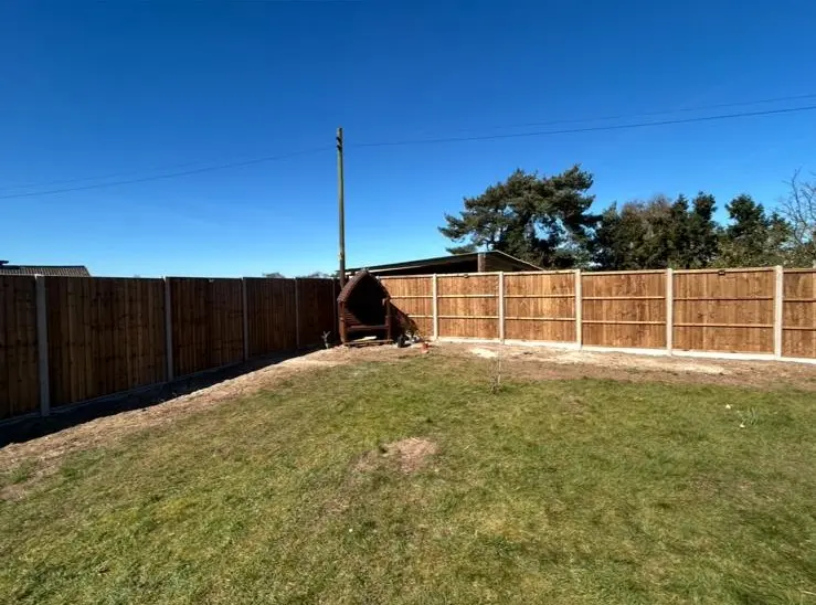 Corner garden fencing with timber panels and concrete posts