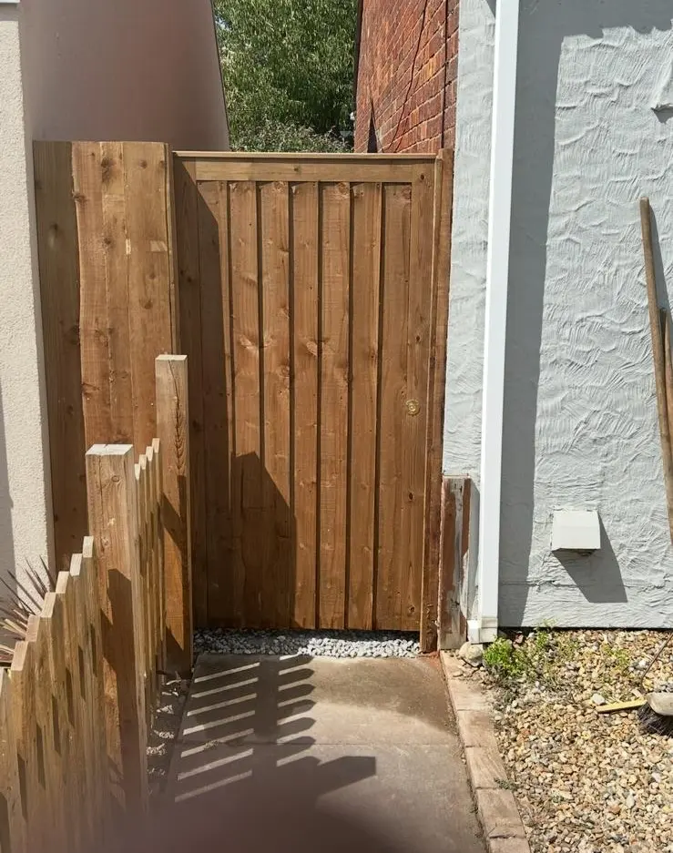 Solid timber side gate installed between two properties with matching fencing