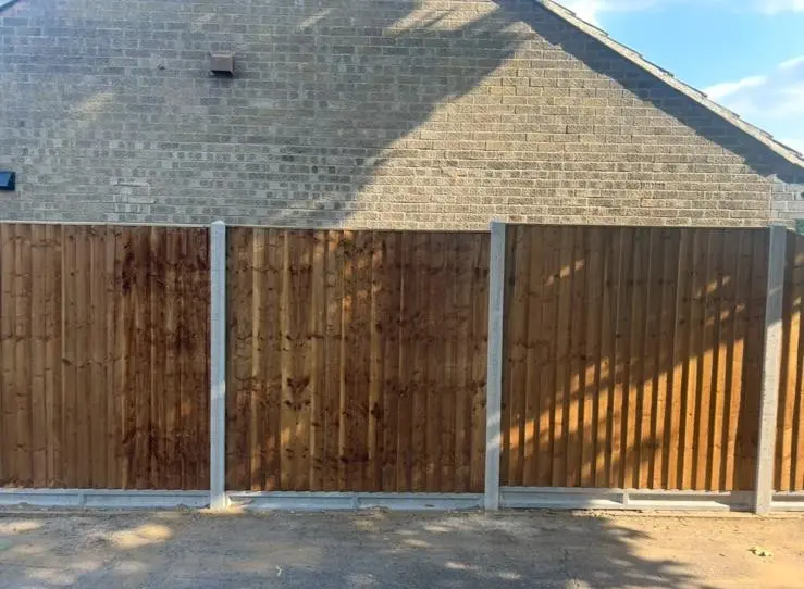 New wooden fence panels installed with concrete posts and gravel boards
